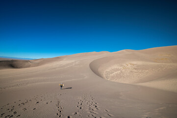 Person with a Sand Board hiking through the desert