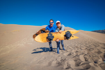Two people holding sand boards