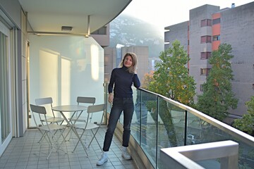 young woman stands on the balcony