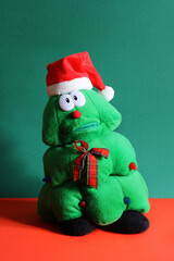 children's Christmas toy in the form of a Christmas tree in a red cap with a sad face. christmas gift for a child