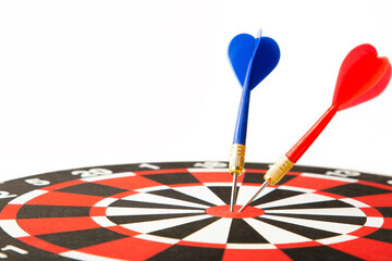 Close up shot red dart arrow on center of dartboard isolated on white, metaphor to target success,...