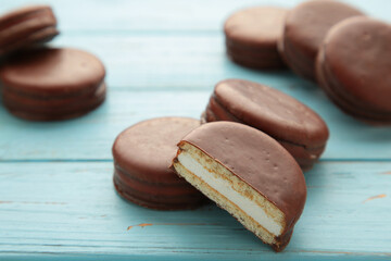 Choco pie chocolate coated snacks on blue wooden background.