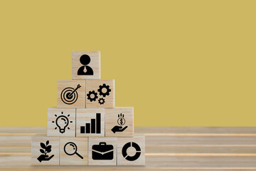 Wood block placed on table with icon business strategy and Action plan on yellow background with...