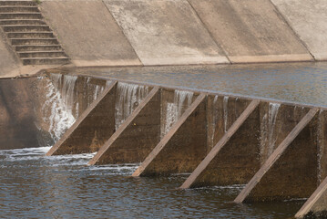 The water flow pass the weir from upper level to lower level.