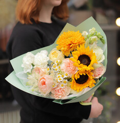 Big stylish flowers bouquet for a gift Women`s Day.  Big beautiful blossoming bouquet of fresh flowers in bright colors wrapped in paper.