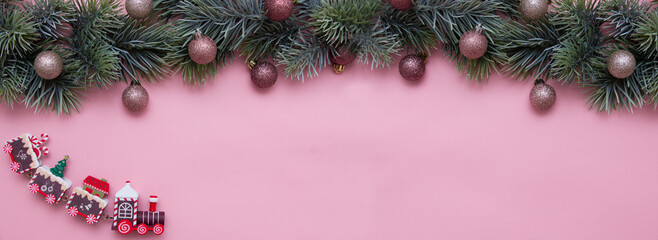 Christmas tree branch decorated with Christmas balls and a toy train. New Year card, top view, flat lay.