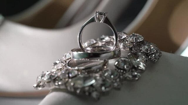Wedding rings in white gold, platinum or silver with a diamond. Bride's engagement ring. White shoes for the bride.
