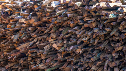 A pile of logs stacked on top of each other. Dry firewood for kindling the stove.