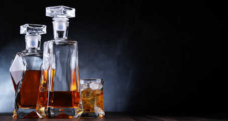 Composition with a glass and  two decanters of whiskey