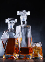 Composition with a glass and  two decanters of whiskey