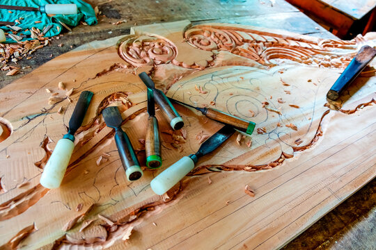 Wood carving. The master carves a pattern on a wooden blank with the help of special tools.