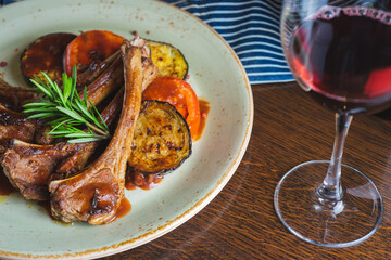 Fried ribs with a glass of red wine on a table in a restaurant close-up
