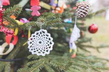 DIY white doily on Christmas tree. Handmade Christmas decoration ideas for children. Environment,...