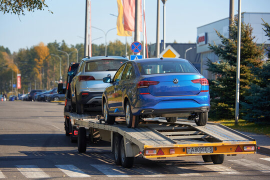 Minsk, Belarus. Oct 2021. Car carrier hauling new VW Polo and VW Taos to car dealership. Car carrying trailer, transporting VW cars at city street.