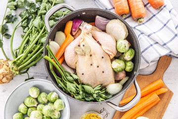 Chicken ready to cook broth with fresh root vegetables and spices