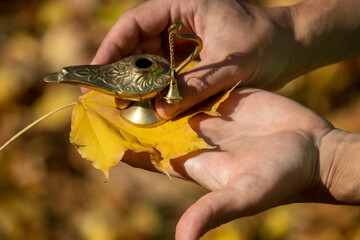 A man holds a gilded magic lamp of Aladdin