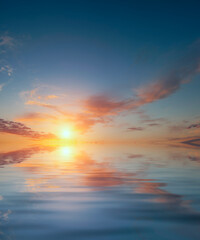 Obraz na płótnie Canvas Sunrise on a warm, calm September evening and some clouds over the ocean.