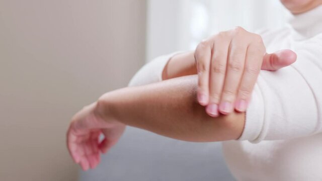 Woman with pain in her elbow uses her hands to massage herself to relieve the pain and help symptoms improve better. Health care concept