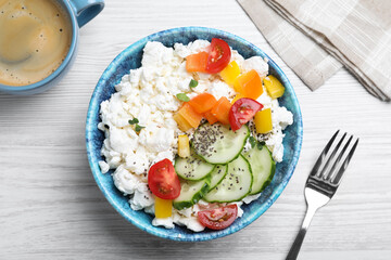 Delicious cottage cheese with vegetables and chia seeds served for breakfast on white wooden table, flat lay