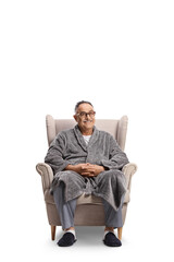 Mature man in a bathrobe and pajamas sitting in an armchair