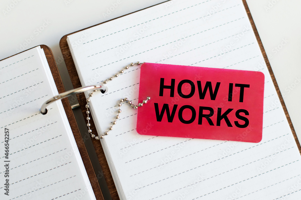 Poster how it works text on a red card that lies on an open notebook