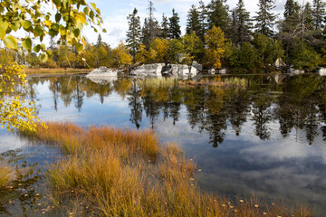 Swamp or lake with megalithic seid boulder stones, dead trees in nature reserve on mountain Vottovaara, Karelia, Russia. Autumn in montain