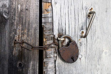 Large rusty lock on the wooden barn door