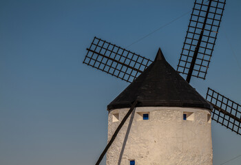 Traditional white windmill on countryside in Castilla la Mancha, Spain, against blue clear sky