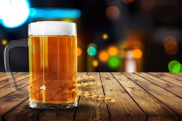 mug of beer, wheat ears, hops on a wooden background