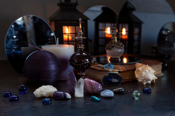 Many different gemstones on the blurred mirrors and  candles background.