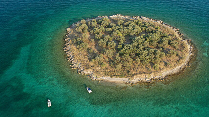 Aerial drone top down photo of small tropical exotic island covered in  limestone with emerald sea