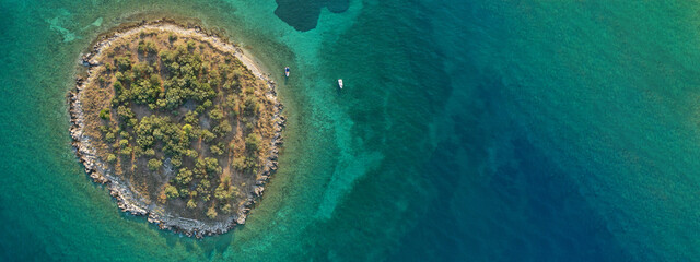 Aerial drone wide photo of small islet of Agios Athanasios with small landmark church next to famous city of Itea, Fokida, Greece