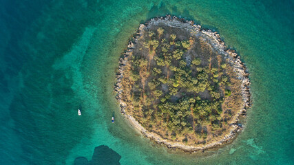 Aerial drone top down photo of small tropical exotic island covered in  limestone with emerald sea