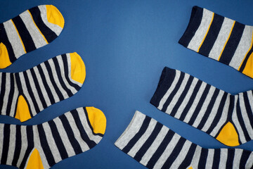 six striped gray and black socks lie on a blue background. top view
