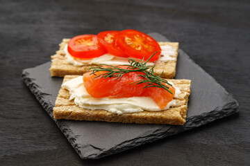 Snack small slyces with soft cheese, red fish and herbs.