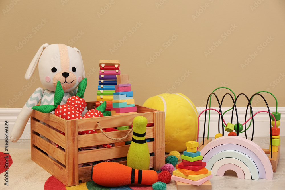 Wall mural set of different cute toys on floor near beige wall