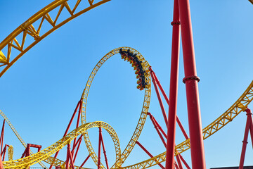 Roller coaster in an amusement park against the blue sky. The concept of attractions and extreme...