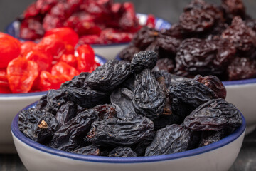 dried raisins in a bowl close-up against the background of other dried fruits