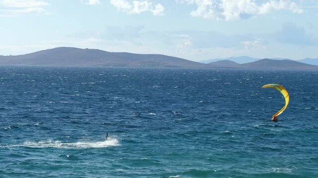 Kitesurfer Kiteboarding on Agios Ioannis Beach, Mykonos, Greece in the Mediterranean Sea