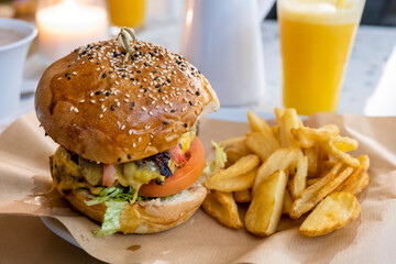 Delicious handmade hamburger, fried potatoes and orange juice