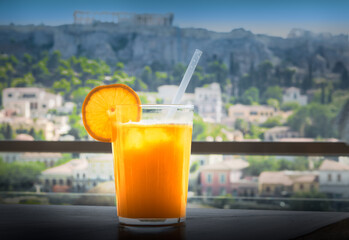 Glass of freshly squeezed orange juice on the table outdoors. 