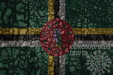 flag of dominica on a old metal rusty cracked wall with text coronavirus, covid, and virus picture.