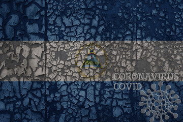 flag of nicaragua on a old metal rusty cracked wall with text coronavirus, covid, and virus picture.