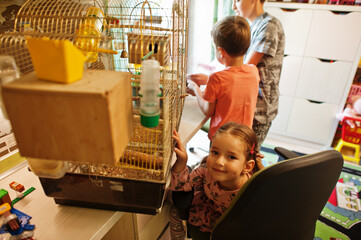 Children holding their favorite pets on hands. Kids playing with hamster,turtle and parrots at home.