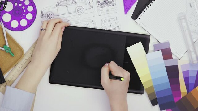 Top view of a creative designer using a graphic tablet while working at his desk