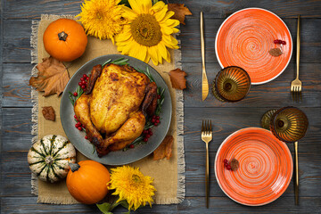 Happy Thanksgiving holiday background. Roasted chicken or turkey, pumpkins for Thanksgiving dinner. Festive table settings for Thanksgiving Day. Copy space