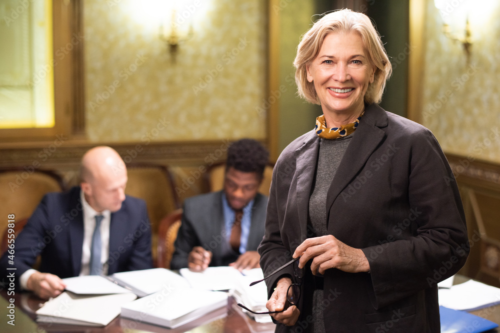 Aufkleber happy experienced female lawyer in formalwear standing in front of camera with two colleagues workin