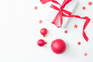 Flat lay frame with red berries, christmas red balls and gift box on a white background. Merry christmas card and copy space for your text