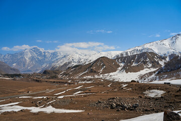 Obraz premium In a mountain valley, a breathtaking landscape of giant covered mountains in the background