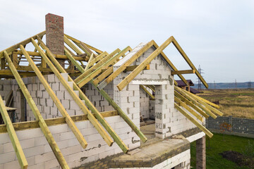 Aerial view of a private house with aerated concrete brick walls and wooden frame for future roof.